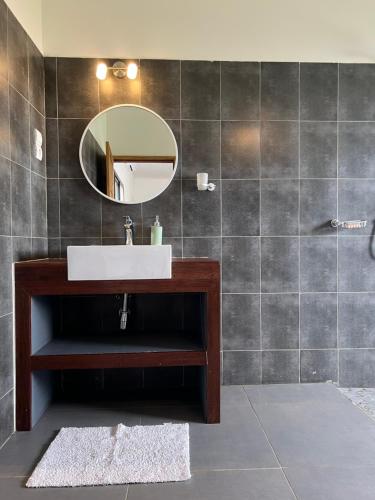 ein Bad mit einem Waschbecken und einem Spiegel in der Unterkunft Chez Diarra in St. Louis