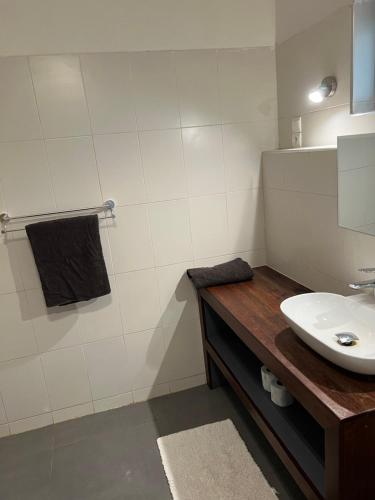 a white bathroom with a sink and a mirror at Chez Diarra in Saint-Louis