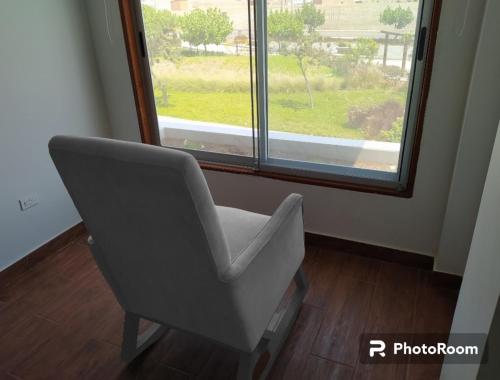 une chaise grise assise devant une fenêtre dans l'établissement El Departamento de Ethan en Asia, à Asia