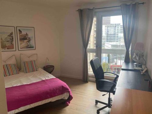 une chambre avec un lit, une chaise et une fenêtre dans l'établissement *Cosy and sweet Apartment* Paris Défense* Porte maillot, à Puteaux