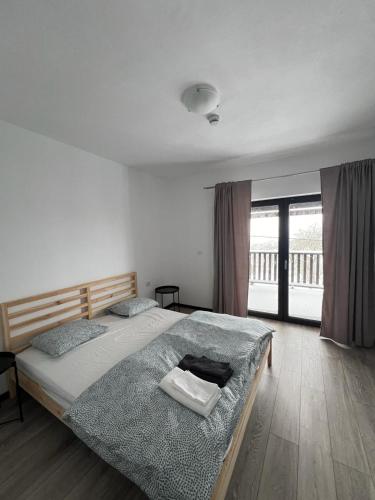 a bedroom with a large bed and a balcony at Casa Roma Lac in Brebu Nou