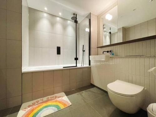 a bathroom with a toilet and a rainbow rug at Modern apartment in heart area in London
