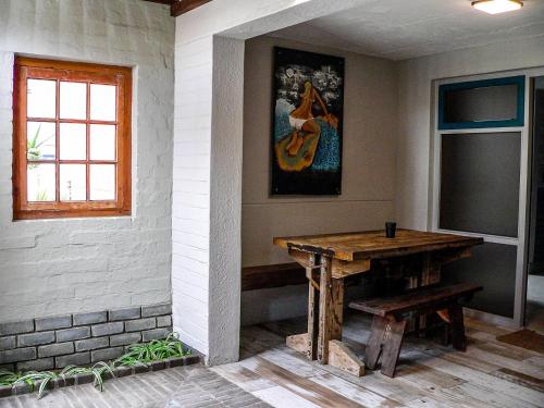 Habitación con una mesa de madera y una pintura en la pared. en de Baken Self-Catering, en Walvis Bay