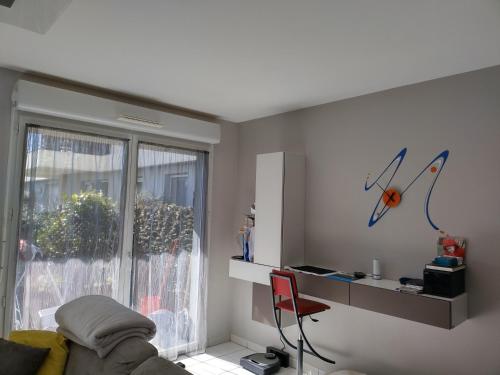 een woonkamer met een bank en een raam bij Appartement standing proche Disney et Paris in Pomponne
