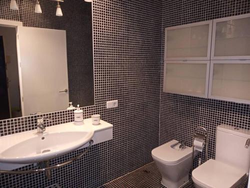 a bathroom with a sink and a toilet and a mirror at Casamar in Almería