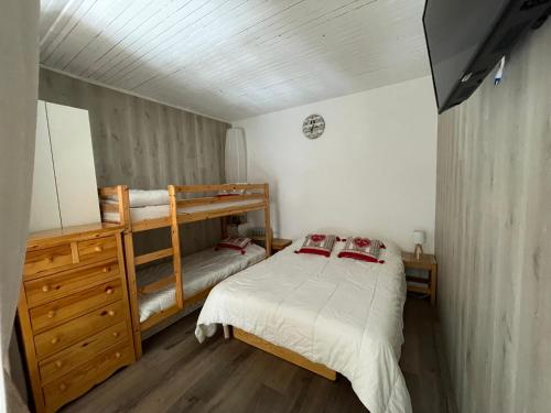 a bedroom with two bunk beds and a dresser at Risoul 1850 Beau Duplex pour 6 pers en plein centre de la station in Risoul