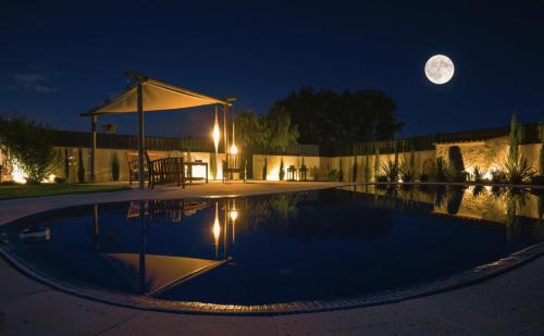 a moon over a swimming pool at night at A Casa Do Lago in Azeitao