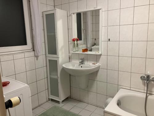 uma casa de banho branca com um lavatório e um espelho em Ferienwohnung im Grünen EG mit Terrasse em Herdecke