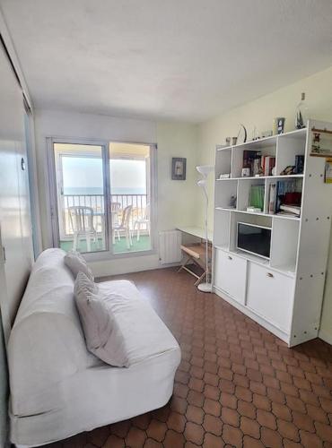 Il comprend un salon doté d'un canapé blanc et d'un balcon. dans l'établissement Appartement belle vue sur mer - 4425, à Soulac-sur-Mer
