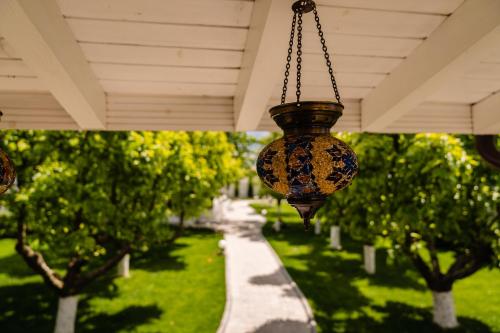 a chandelier hanging from a porch with trees at NB Boutique in Tuzla