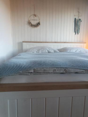 1 cama con edredón azul y almohadas en Ferienwohnung Festhof Nirgendwo, en Langewahl