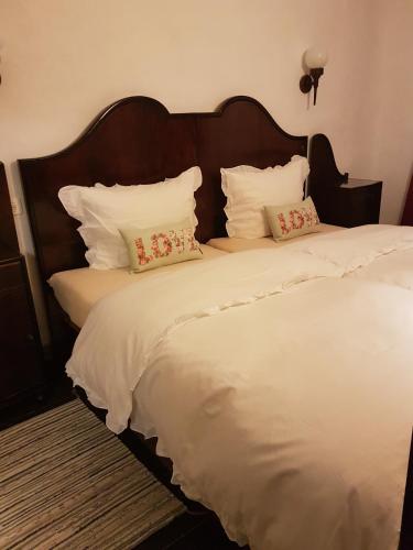 1 cama grande con sábanas y almohadas blancas en Ferienwohnung Festhof Nirgendwo, en Langewahl