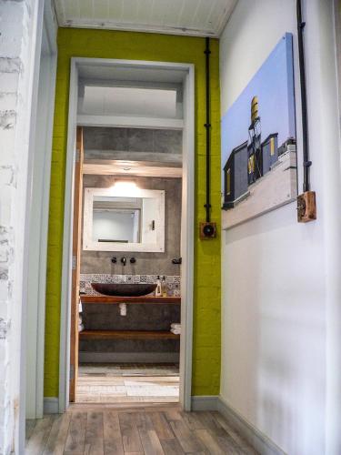 a bathroom with green and yellow walls and a sink at de Baken Self-Catering in Walvis Bay