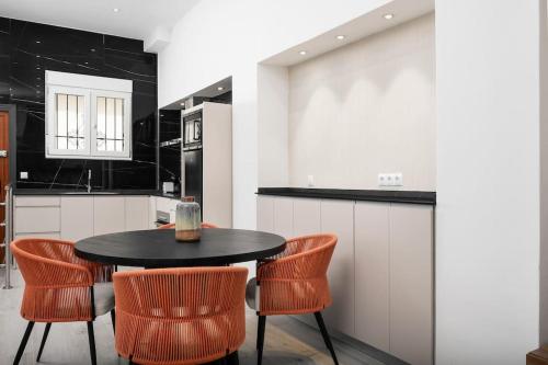 une cuisine avec une table noire et des chaises orange dans l'établissement Modern 1-Bed Apartment with Wi-Fi, à Torremolinos