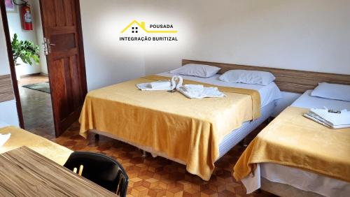 a hotel room with two beds with towels on them at Pousada Integração Buritizal in Buritizal