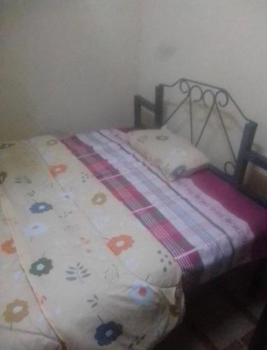 a small bed in a room with a blanket on it at Royal Villa Guest House in Baragoi