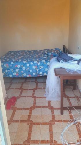 a bedroom with a bed and a table and a tiled floor at Royal Villa Guest House in Baragoi
