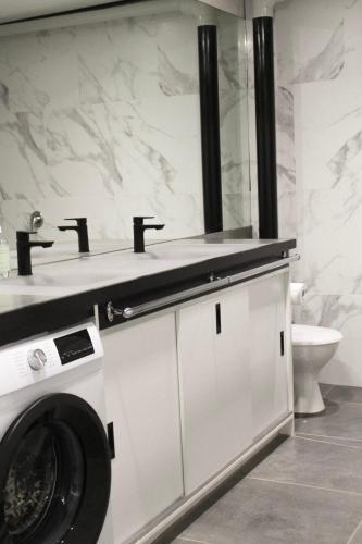 a bathroom with a washing machine and a sink at Big Modern Loft Apt - Central - 7 Beds, 9 Guests - Workers, Families, Groups, Teams in Narrabundah