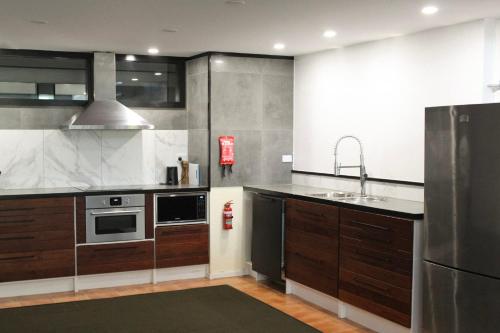 a kitchen with wooden cabinets and a stainless steel appliance at Large Loft Modern Apt for Big Groups in Narrabundah