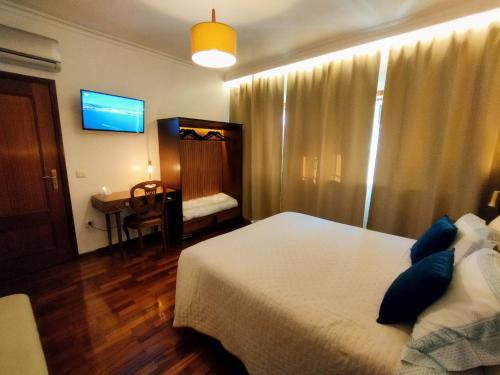 um quarto de hotel com uma cama e uma televisão em Casa do Rio nas Termas de São Pedro do Sul