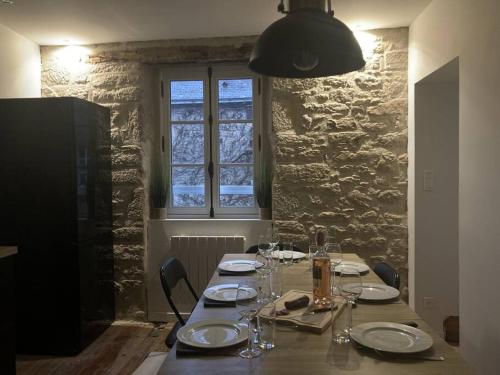 une table de salle à manger avec des assiettes et des verres dessus dans l'établissement Kentañ - Maison insolite intra-muros à Guérande, à Guérande