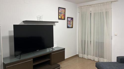 sala de estar con TV de pantalla plana en un centro de entretenimiento en FH CAMP PRECIÓS II, en Altea