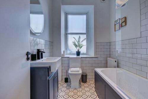 uma casa de banho com uma banheira, um WC e um lavatório. em Coorie Doon - Aparthotel - Troon em Troon