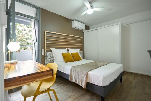 - une chambre avec un lit, une table et un bureau dans l'établissement La Suite Azur, à Pointe-à-Pitre