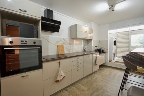 a large kitchen with white cabinets and appliances at La Suite Azur in Pointe-à-Pitre