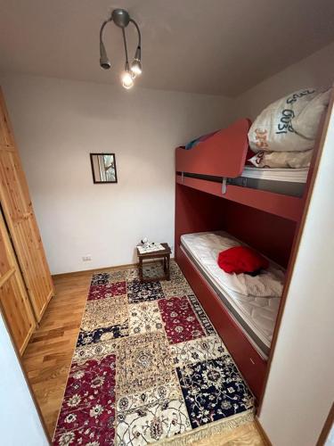 a small room with two bunk beds and a rug at Giappetto House in Limone Piemonte