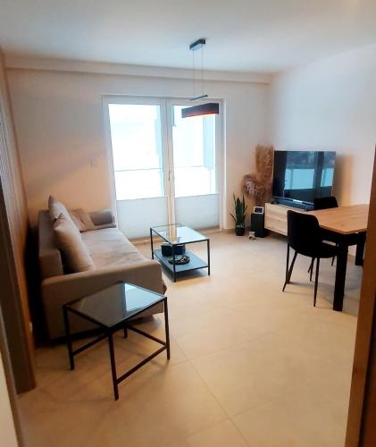 a living room with a couch and a table at Design Apartment in Bolszewo