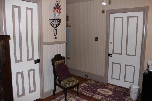 a room with two white doors and a chair at Carriage Stop Bed & Breakfast in Palmyra