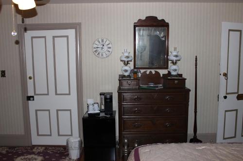 a bedroom with a dresser and a clock on the wall at Carriage Stop Bed & Breakfast in Palmyra