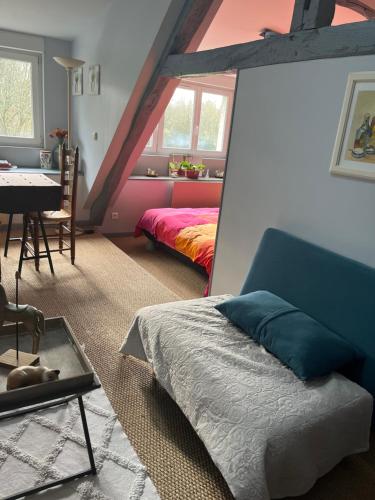 a bedroom with a bed and a table and a dining room at Le Vieux Moulin Chamant Senlis 60300 in Chamant
