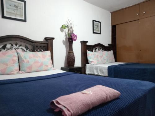 um quarto com duas camas e um vaso com flores em Historico maya em Guatemala
