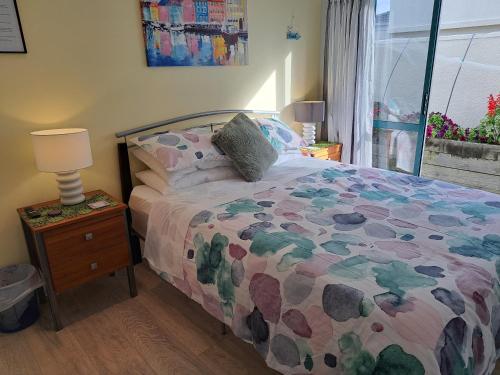 a bedroom with a bed and a lamp on a night stand at Sunbrae Beach Sands Y in Mount Maunganui