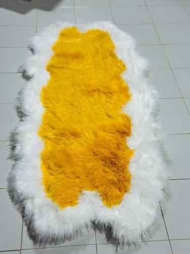 una alfombra amarilla y blanca en el suelo en JP Immo, en Dakar