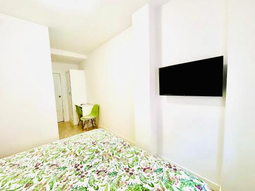 um quarto com uma cama e uma televisão na parede em Hostal La Taberna em Arenas de San Pedro