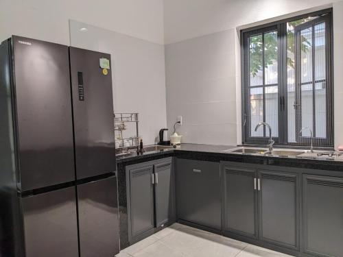 a kitchen with a stainless steel refrigerator and a sink at Thong Dong Homestay in Phước Lý