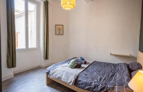 une chambre avec un lit avec un animal en peluche dessus dans l'établissement Appartement cosy au cœur de Toulon, à Toulon