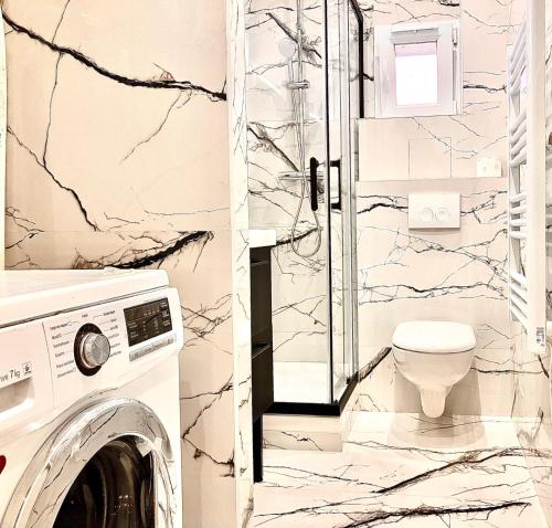 a bathroom with a toilet and a washer and dryer at PARIS CITY-Le Raincy - Facing station - 4 to 8 Pers in Le Raincy