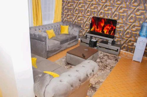 a living room with a couch and a fireplace at Deci Homes in Ruaka