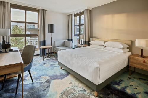 a bedroom with a large bed and a desk and a desk at Hamburg Marriott Hotel in Hamburg