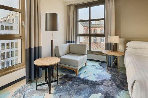 a hotel room with a bed and a chair and a window at Hamburg Marriott Hotel in Hamburg