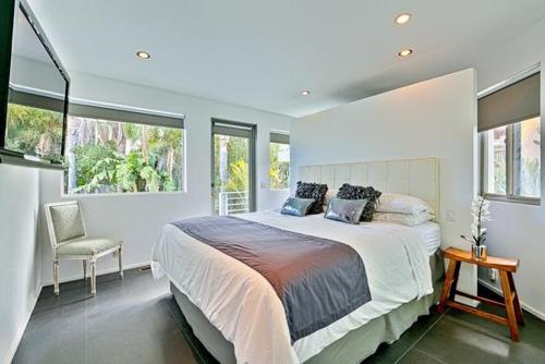 Un dormitorio con una cama grande y ventanas. en Double Ocean View Villa Laguna Beach, en Laguna Beach
