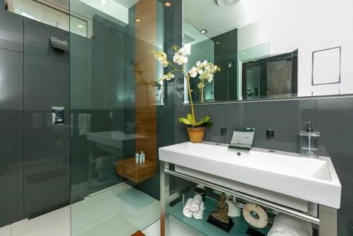 Un baño con lavabo y ducha de cristal. en Double Ocean View Villa Laguna Beach, en Laguna Beach
