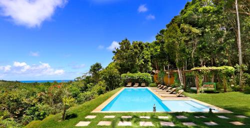 a swimming pool in the middle of a yard with trees at Casa Baiana Pousada & Aconchego in Trancoso