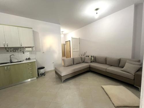 uma sala de estar com um sofá e uma cozinha em DESA Seaside Apartment em Vlorë