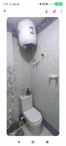 a bathroom with a toilet and a water tank at فيلا دوبلكس على البحر مباشره in Arish