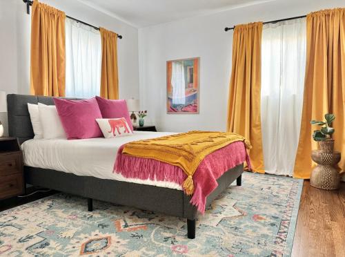 a bedroom with a bed with pink and yellow pillows at Spotless Modern Home Close to LAX & Sofi Stadium in Inglewood